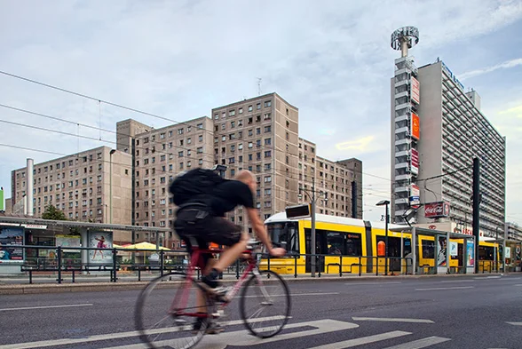 Fahrradfahrer, im Hintergrund eine gelbe Straßenbahn der Berliner Verkehrsbetriebe